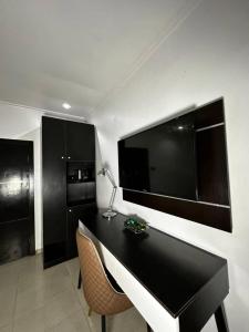 a room with a desk and a large television on the wall at ModexD'Crib in Lagos