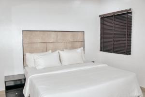 a large white bed in a bedroom with a window at ModexD'Crib in Lagos