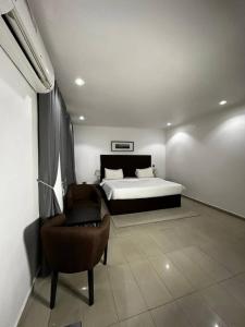 a bedroom with a bed and a chair in it at ModexD'Crib in Lagos