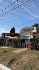 a house with a gate in front of it at cabaña EL CHALECITO DE ANA in Villa del Dique