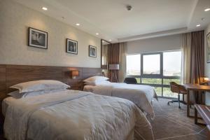 a hotel room with three beds and a window at Sheraton Novi Sad in Novi Sad +68 photos