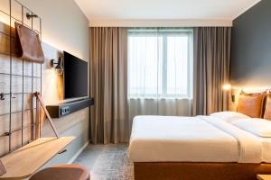 a hotel room with a bed and a window at Moxy Berlin Airport in Schönefeld