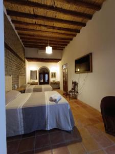 a bedroom with two beds and a flat screen tv at Posada Santa Isabel in Parras de la Fuente