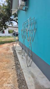 two metal objects are leaning against a blue building at ZIRA STAY PENARIK - Nuha Room in Kampong Ru Sepuloh