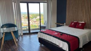 a bedroom with a bed and a large window at Central Suites in Tarapoto