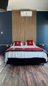 a bedroom with a large bed with red pillows at Central Suites in Tarapoto