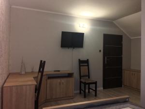 een woonkamer met 2 stoelen en een televisie aan de muur bij Laura in Bełchatów