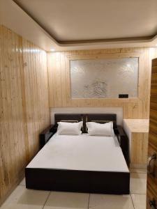a bedroom with a large bed with white sheets at Bhagirathi Homestay in Joshīmath