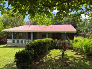 a small house with a red roof in a yard at Quinta los almendros in Jabillos