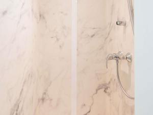 a white marble shower with a shower head at Ibis budget Brest Sud Plougastel - Hôtel rénové in Plougastel-Daoulas