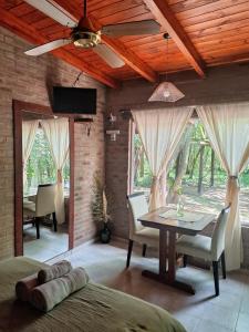 a bedroom with a table and chairs and a ceiling fan at Complejo Tiú Mayú in La Granja +6 photos