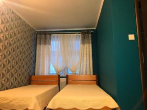 1 dormitorio con 2 camas y ventana en Laura en Bełchatów