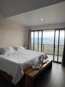 a bedroom with a bed and a large window at Villas Amíwa in Alajuelita