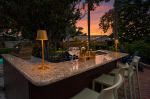 a bar with white chairs and a table with a lamp at SolMaré - 5BR, Pool, Spa, Mini-Golf, Outdoor Kitchen, Fire Pit, Game Room in Bradenton