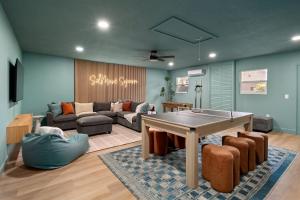 a living room with a ping pong table and a couch at SolMaré - 5BR, Pool, Spa, Mini-Golf, Outdoor Kitchen, Fire Pit, Game Room in Bradenton