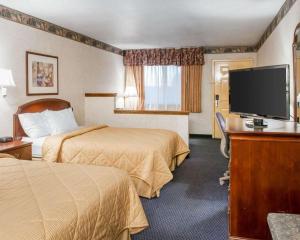 a hotel room with two beds and a flat screen tv at Rodeway Inn Tucumcari in Tucumcari