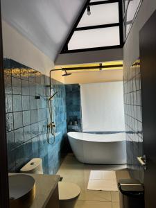 a bathroom with a tub and a toilet and a sink at Villas Amíwa in Alajuelita