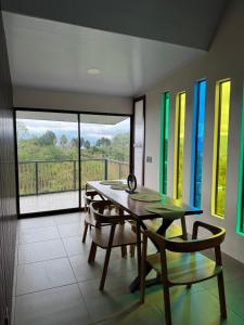 a dining room with a table and chairs and windows at Villas Amíwa in Alajuelita