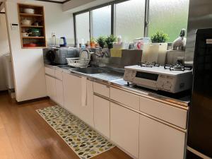 a kitchen with a sink and a stove at 一棟貸ひなたぼっこくらなみ in Nagano
