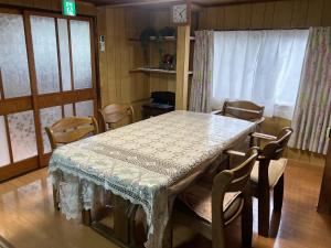 a table and chairs in a room with a table and a window at 一棟貸ひなたぼっこくらなみ in Nagano +16 photos