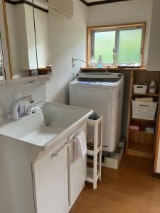 a small kitchen with a sink and a dishwasher at 一棟貸ひなたぼっこくらなみ in Nagano