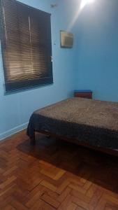 a bedroom with a bed in a room with a window at Hotel Flamingos in Santos