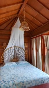 a bed in a room with a wooden ceiling at Tentrem Bungalow in Labuan Bajo