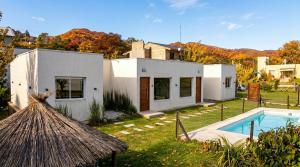 a house with a swimming pool in a yard at AROMA DEL POTRERO PISCINA CLIMATIZADA CUBIERTA disponible desde Septiembre in Potrero de los Funes