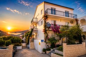 a building with a sunset in the background at Apartments Butkovic in Hvar