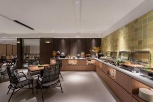 a restaurant with tables and chairs and a buffet at SOVIS PLUS HOTEL in Shenzhen
