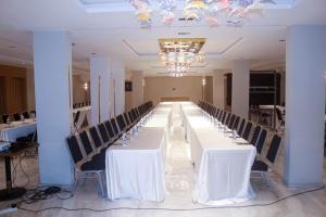 ein langer Tisch mit weißen Tischen und Stühlen in einem Raum in der Unterkunft Platinum Hôtel Spa Abidjan Cocody in Abidjan + 109 Fotos