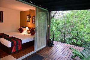 ein Zimmer mit Bett und Balkon mit Aussicht in der Unterkunft The Backwaters Lodge in Wilpattu Nationalpark
