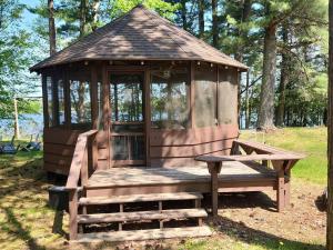 a wooden gazebo with a bench in a park at Black Hawk in Mercer