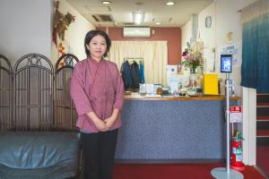 a woman is standing in front of a counter at 美咲旅館 in Sakaide