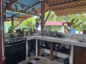 a kitchen with a stove and a counter top at Cozy cabin by the sea in Cahuita +17 photos