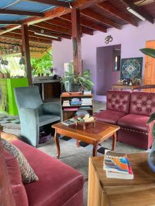 a living room with couches and a table at Cozy cabin by the sea in Cahuita