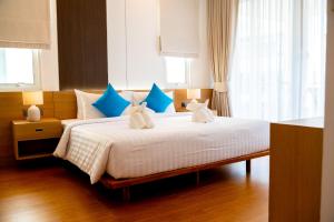 a bedroom with a bed with blue and white pillows at Krabi One Bedroom Pool View in Klong Muang Beach +8 photos