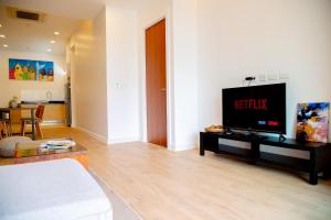 a living room with a flat screen tv on a table at Krabi One Bedroom Pool View in Klong Muang Beach
