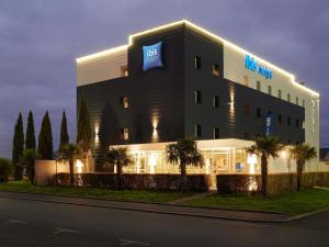 a hotel with a sign on the side of a building at Ibis Budget Ancenis in Mésanger