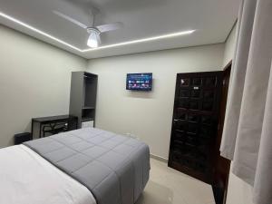 a bedroom with a bed and a tv on the wall at Hostel Pouso Gru - Translado Aeroporto Gru grátis in Guarulhos +23 photos