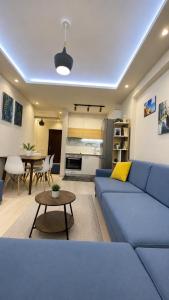 a living room with a blue couch and a table at Sirel Home in Durrës +18 photos