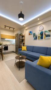 a living room with a blue couch and a kitchen at Sirel Home in Durrës
