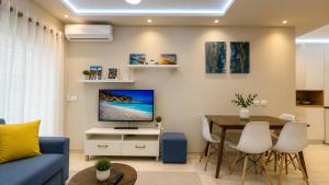 a living room with a blue couch and a table at Sirel Home in Durrës