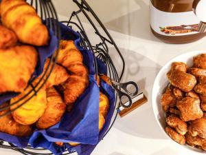 a basket filled with breads and a bowl of pastries at ibis budget Amberieu en Bugey/Chateau Gaillard A42 in Château-Gaillard +37 photos