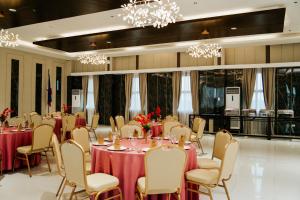 ein Festsaal mit Tischen, Stühlen und Kronleuchtern in der Unterkunft Madayaw Hotel Tagum in Tagum