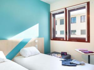 a room with two beds and a window at ibis budget Perpignan Centre - Hôtel Economique au Centre ville de Perpignan in Perpignan
