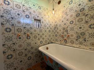 a bathroom with a tub and floral wallpaper at La Puerta - Pueblito Boyacense in Duitama +28 photos