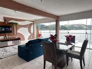 a living room with a table and a blue couch at Meneghetti Mangaratiba in Mangaratiba