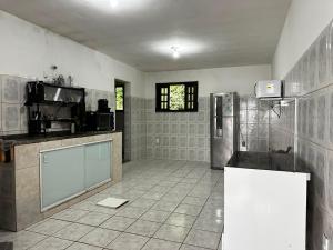 a kitchen with a refrigerator and a tiled floor at Meneghetti Mangaratiba in Mangaratiba