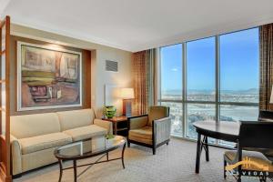 a living room with a couch and a table at Deluxe Spa 24th floor Signature Studio with Mountain View in Las Vegas